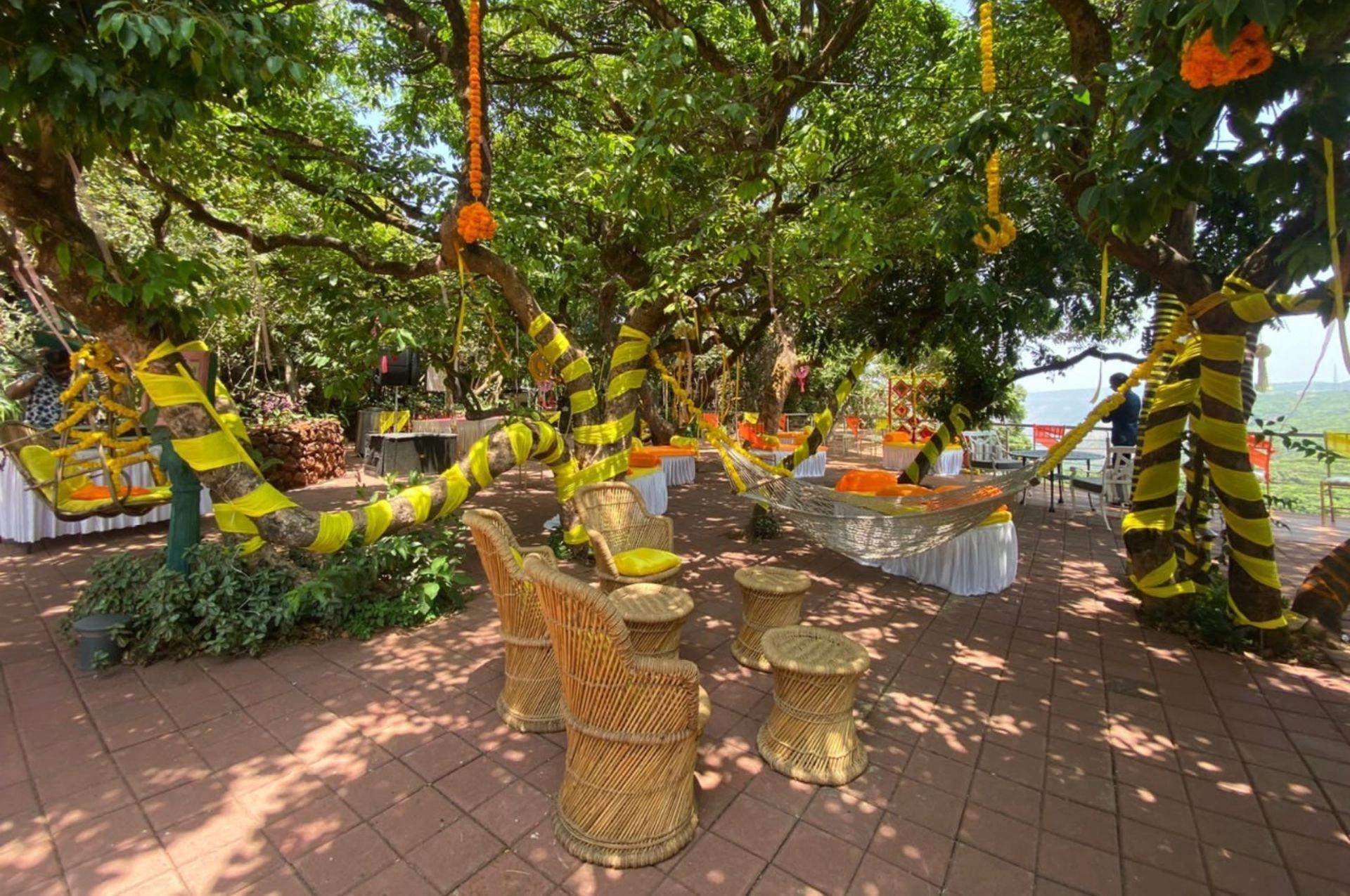 Forest canopy setup with colorful decor and furniture for an event at Ramsukh Resort, Mahabaleshwar.